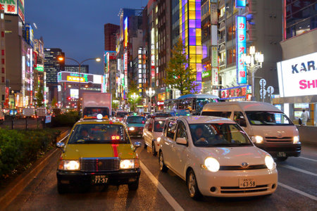 TOKYO, JAPAN - NOVEMBER 30, 2016: Cars drive under the neon lights of Shinjuku district of Tokyo, Japan. Tokyo is the capital city of Japan. 37.8 million people live in its metro area.