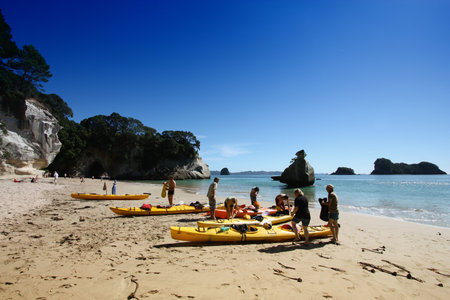 COROMANDEL, NEW ZEALAND - MARCH 11, 2008: Sea kayakers visit Cathedral Cove, Coromandel, New Zealand. Coromandel Peninsula is considered ultimate sea kayaking destination with its crystal clear water.のeditorial素材