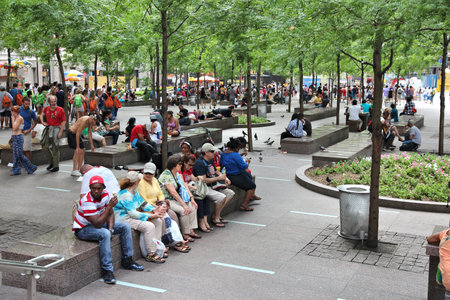 NEW YORK, USA - JULY 4, 2013: People sit in Zuccotti Park in Lower Manhattan, New York. Almost 19 million people live in New York City metropolitan area.のeditorial素材