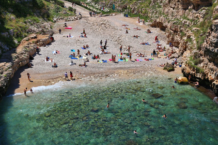 POLIGNANO A MARE, ITALY - MAY 29, 2017: People visit the unique beach of Polignano a Mare in Apulia, Italy. With 50.7 million annual visitors Italy is one of the most visited countries.のeditorial素材