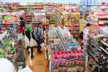TOKYO, JAPAN - DECEMBER 4, 2016: Shopper visits a discount 100-yen store with variety of household...