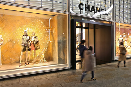 TOKYO, JAPAN - DECEMBER 4, 2016: People walk by Chanel high fashion store in Ginza district of Tokyo, Japan. Ginza is a legendary shopping area in Chuo Ward of Tokyo.のeditorial素材