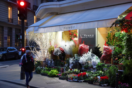 PARIS, FRANCE - DECEMBER 10, 2019: Person walks by a flower shop in 7th Arrondissement of Paris, France. Paris is the biggest city in France, with 12.5 million people living in its metro area.のeditorial素材