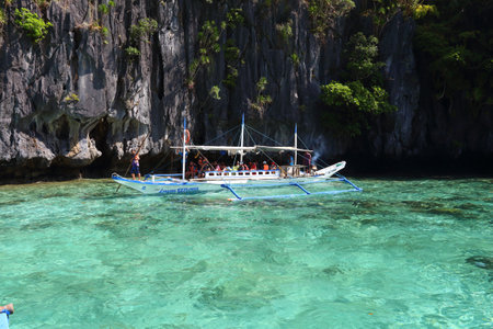 PALAWAN, PHILIPPINES - DECEMBER 1, 2017: Tourists ride outrigger bangka boat on island hopping tour in Palawan, Philippines. 6 million foreign tourists visited Philippines in 2016.のeditorial素材