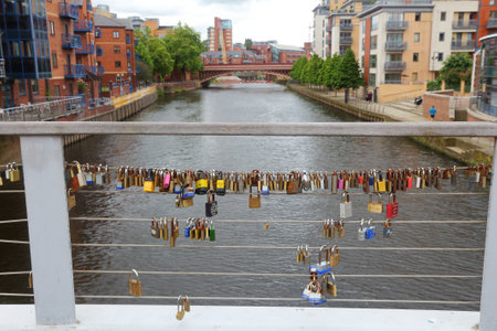 LEEDS, UK - JULY 12, 2016: Love padlocks on a foot bridge crossing River Aire in The Calls, former industrial area in Leeds. Now it's redeveloped with restaurants and apartment buildings.のeditorial素材