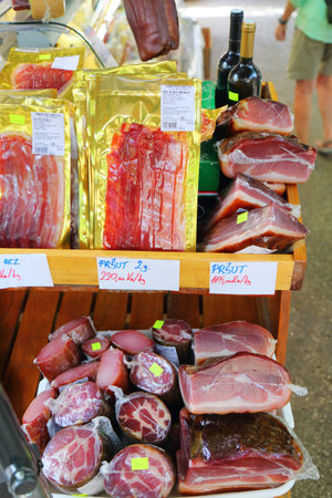 TROGIR, CROATIA - JUNE 23, 2021: Local cured hams (Croatian language: prsut) and meats a food marketplace Trogir, Croatia. Trogir is a medieval town in Dalmatia listed as UNESCO World Heritage Site.のeditorial素材