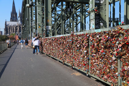 COLOGNE, GERMANY - SEPTEMBER 22, 2020: People visit love padlocks of Hohenzollern Bridge (Hohenzollernbrucke) in Cologne city, Germany.のeditorial素材