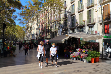 BARCELONA, SPAIN - OCTOBER 7, 2021: People walk famous Rambla avenue in Barcelona, Spain. Barcelona is the 2nd largest city of Spain.のeditorial素材