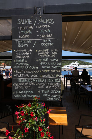 VIS, CROATIA - JUNE 22, 2021: Croatian and English language menu in a local restaurant of Vis....