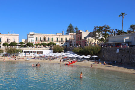 APULIA, ITALY - MAY 30, 2017: Beachgoers visit Santa Maria Al Bagno beach in Puglia region, Italy. With 50.7 million annual visitors Italy is one of the most visited countries.のeditorial素材