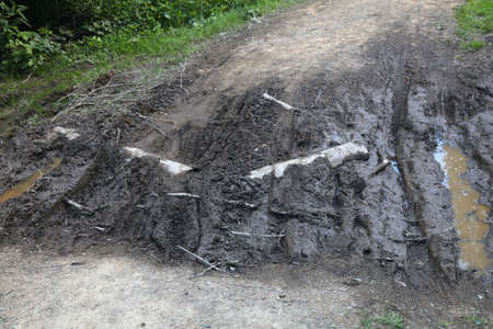 Muddy local road in Wisla, Poland. Rural road problems.の写真素材