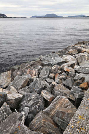 Banded gneiss stone boulders used in rubble mound breakwater in Norway. Harbor infrastructure in Alesund, Norway.の写真素材