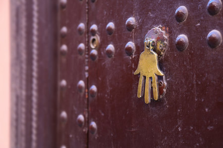 Hamsa, Hand of Fatima door knocker. Traditional Moroccan architecture feature in Marrakech, Morocco.