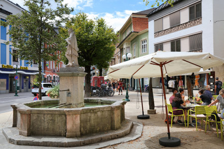 BAD ISCHL, AUSTRIA - AUGUST 2, 2022: People visit downtown Bad Ischl in Salzkammergut region of Austria. Bad Ischl is a spa town and a popular tourist destination.のeditorial素材