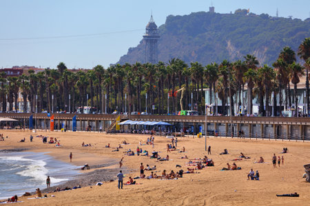 BARCELONA, SPAIN - OCTOBER 7, 2021: People spend time on Barceloneta beach in Barcelona, Spain. Barcelona is the 2nd largest city of Spain.のeditorial素材