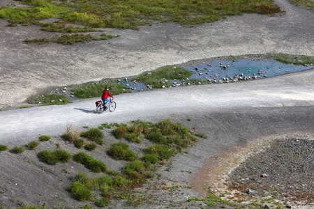 GELSENKIRCHEN, GERMANY - SEPTEMBER 17, 2020: Cyclist visits repurposed recreation area of  Rheinelbe slag heap in Gelsenkirchen city, a part of Ruhrgebiet formerly industrial area.のeditorial素材