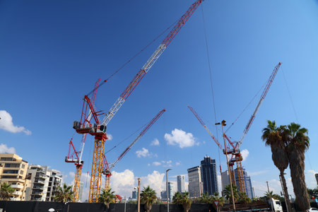 TEL AVIV, ISRAEL - NOVEMBER 2, 2022: Construction cranes of Shikun and Binui construction company in Tel Aviv, Israel. Shikun & Binui is one of largest construction companies in Israel.のeditorial素材