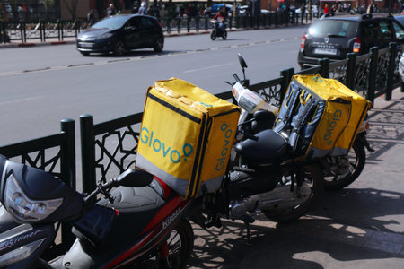 MARRAKECH, MOROCCO - FEBRUARY 21, 2022: Glovo mobile app food delivery scooters parked in the sidewalk in Marrakech, Morocco.のeditorial素材