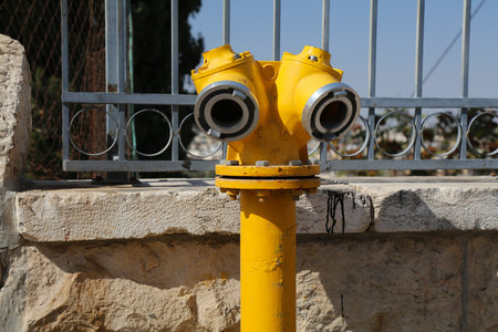 Fire hydrant in Jerusalem, Israel. Yellow standpipe. Fire safety infrastructure.の写真素材