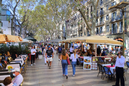 BARCELONA, SPAIN - OCTOBER 7, 2021: People walk along famous Rambla avenue in Barcelona, Spain. Barcelona is the 2nd largest city of Spain.のeditorial素材