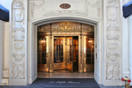 NEW YORK, USA - JULY 5, 2013: Brass revolving door of 24 Fifth Avenue coop residential building in New York.のeditorial素材