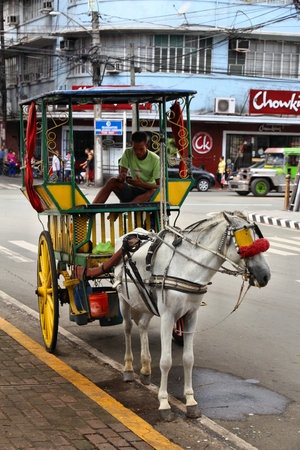 MANILA, PHILIPPINES - NOVEMBER 25, 2017: Driver waits in horse carriage in Intramuros district, Manila, Philippines. Horse tours are a popular tourist attraction in Manila.のeditorial素材