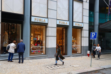 LISBON, PORTUGAL - JUNE 6, 2018: People walk by Furla luxury fashion brand shop at Avenida da Liberdade in Lisbon. This famous boulevard is renowned for luxury brand shopping and prime real estate.のeditorial素材