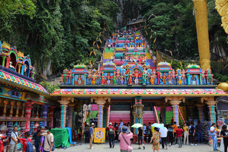 BATU CAVES, MALAYSIA - MARCH 17, 2024: Pilgrims visit Batu Caves temple complex in the outskirts of Kuala Lumpur. Batu Caves is on of most recognized Hindu religion centres outside India.のeditorial素材