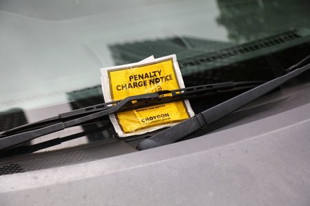 CROYDON, UK - JULY 8, 2024: Penalty charge notice behind windshield wiper, parking violation fine in Croydon, Greater London, UK.のeditorial素材