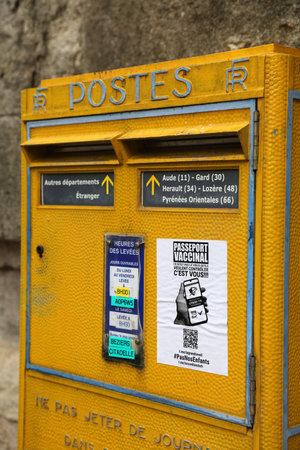 BEZIERS, FRANCE - OCTOBER 3, 2021: Public yellow mailbox of La Poste in Beziers, France. La Poste is...