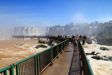 IGUACU NATIONAL PARK, BRAZIL - OCTOBER 9, 2014: People visit waterfall walkways in Iguacu National Park in Brazil. The park was established in 1939 and is a UNESCO World Heritage Site.のeditorial素材