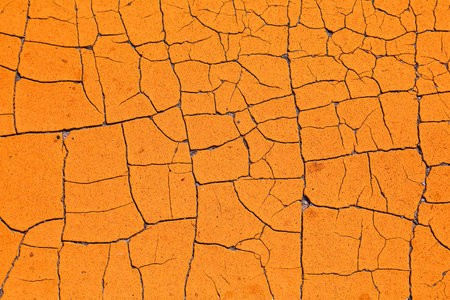 Orange grungy background. Retro style texture of peeling paint. Weathered cracked paint grunge background surface.の写真素材