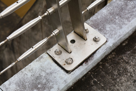 Steel post shoe screwed to concrete. Stainless steel turnbuckles for metal balustrade. City infrastructure in Malaysia.の写真素材