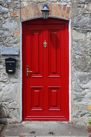 Red door in Adare village in County Limerick in Ireland. Adare is designated as a heritage town.の写真素材