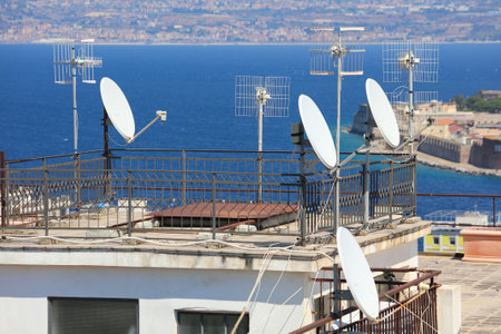 Rooftop TV and satellite dish antennas on an apartment building in Messina city in Sicily, Italy.の写真素材