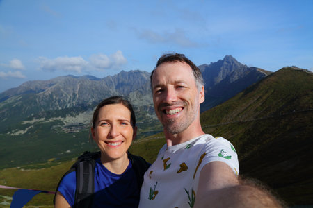 Couple selfie in Tatry mountains in Poland. Orla Perc and Swinica view in September. Middle aged...