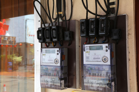 MALACCA, MALAYSIA - MARCH 15, 2024: Electricity meters mounted on house wall in Malacca city in Malaysia.のeditorial素材
