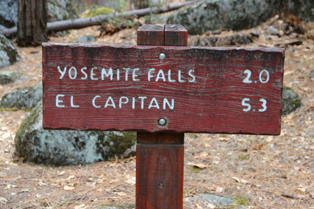 Trail distance sign to Yosemite Falls and El Capitan mountain in Yosemite National Park, California, United States.の写真素材