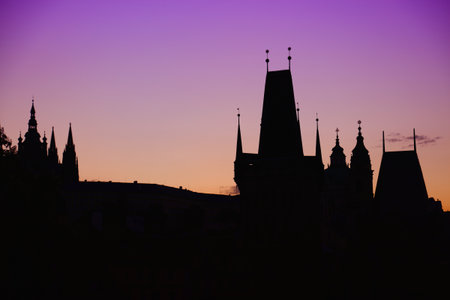 Towers of Prague, Czech Republic. Black monument silhouette against sunset light.