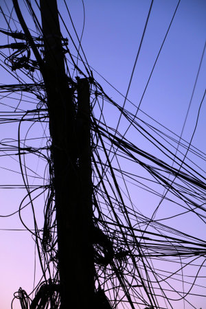 Tangled messy wires - city cables against the sky in Tirana, Albania. Utility cables, internet cables and telephone wires.の写真素材