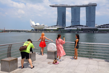SINGAPORE CITY, SINGAPORE - MARCH 13, 2024: People visit a viewpoint terrace in downtown Singapore City, with Marina Bay Sands hotel in background.のeditorial素材