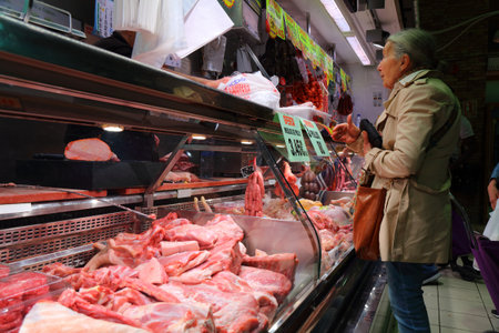 ALICANTE, SPAIN - APRIL 15, 2025: People visit the a butcher shop in Central Market (Mercat Central) in Alicante, Spain.のeditorial素材