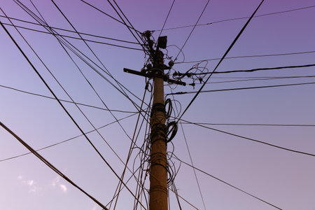 Tangled messy wires - city cables against the sky in Berat, Albania. Utility cables, internet cables...