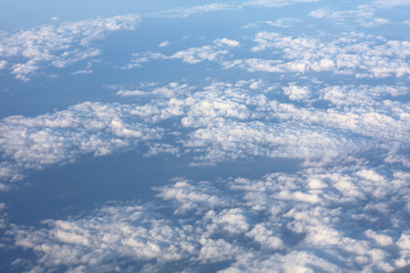 Aircraft window view of fluffy white clouds over Romania, Europe. Aerial view cloudscape.の写真素材