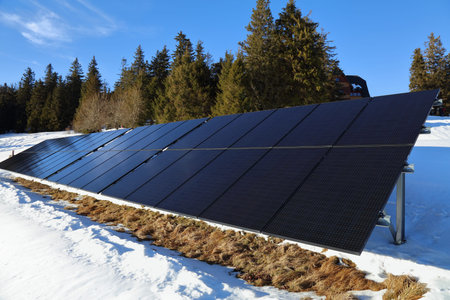 Solar panels mounted on frame in next to a remote mountain lodge in Poland. Photovoltaic energy...