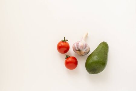 Fresh red cherry tomatoes with garlic and avocado isolated on a white background wtih a copyspace