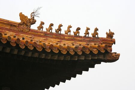 Imperial rooftop of a building inside the Forbidden City in Beijing with various statues of mystical...