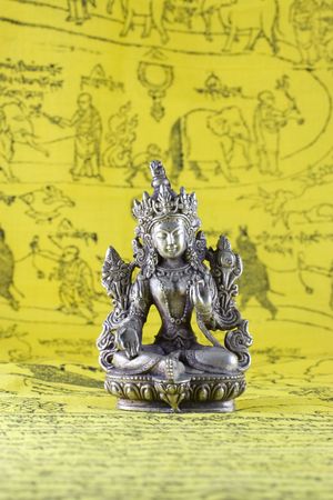 The statuette of a dharmapala diety on a yellow background. Representation of tantric buddhism from Tibet.の写真素材