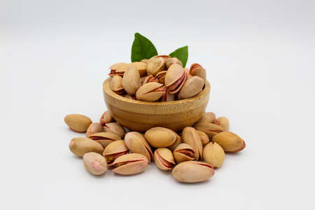 Pile of fresh pistachios isolated on white background. Pile of pistachios in bowl. Organic...