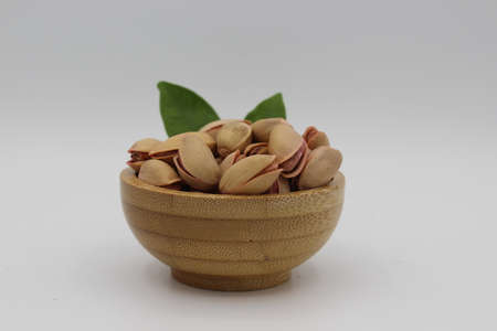 Pile of fresh pistachios isolated on white background. Pile of pistachios in bowl. Organic...